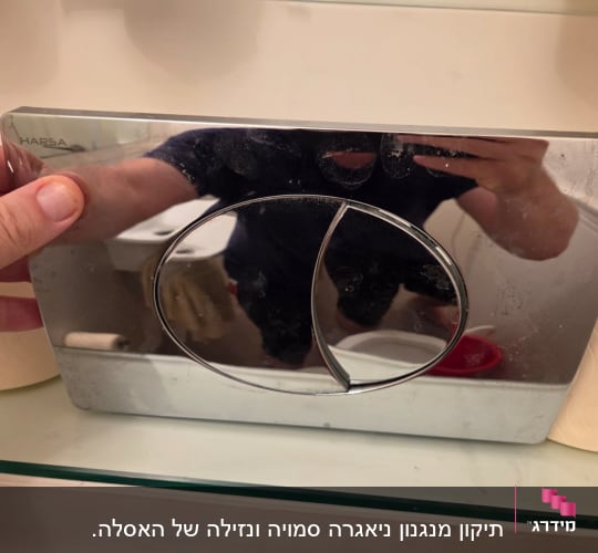 יד מחזיקה לוח מתכת של מיכל הדחה בשירותים
